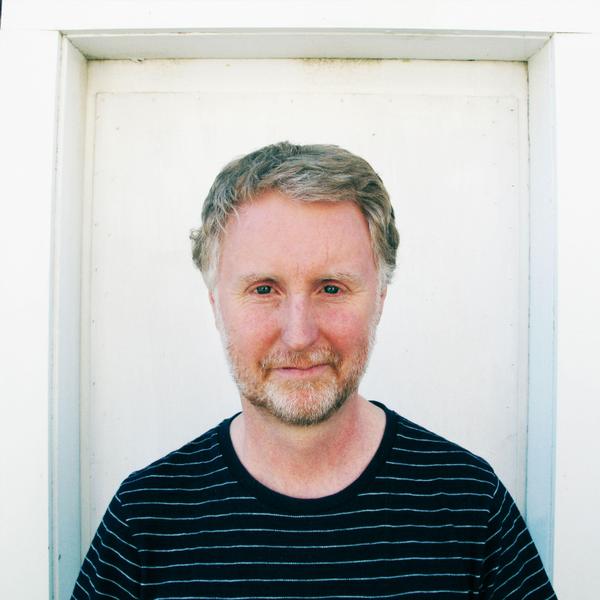 A man standing in front of a white door.